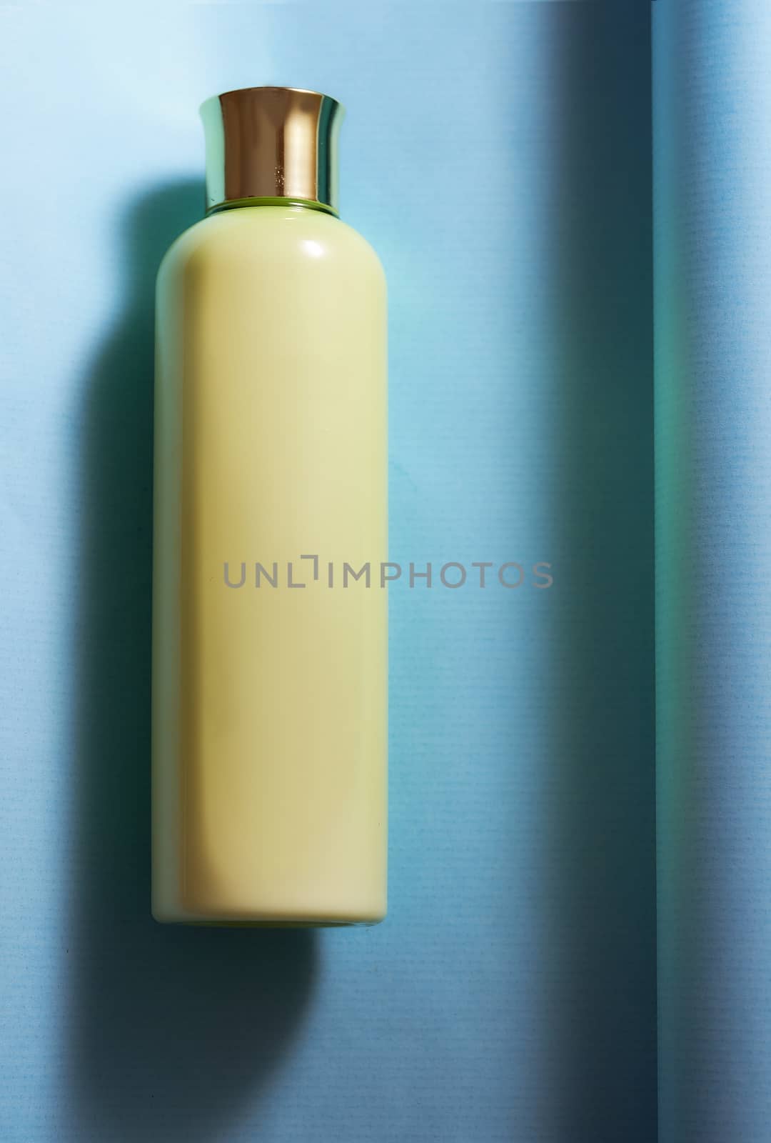 Yellow vial for cosmetics on a blue background. High quality photo