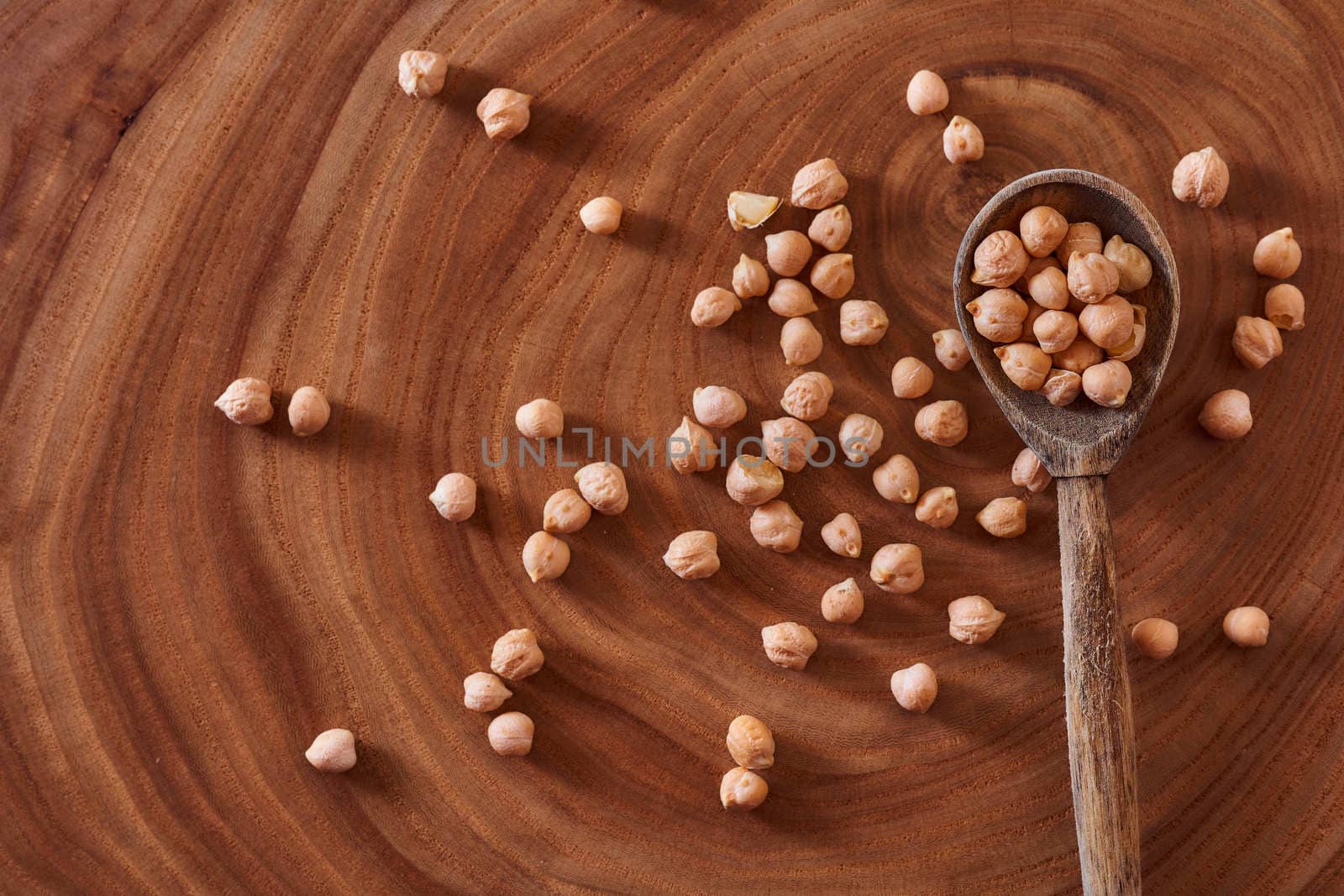 Superfood chickpeas lie in wooden background with spoon. Close-up. Top view. High quality photo