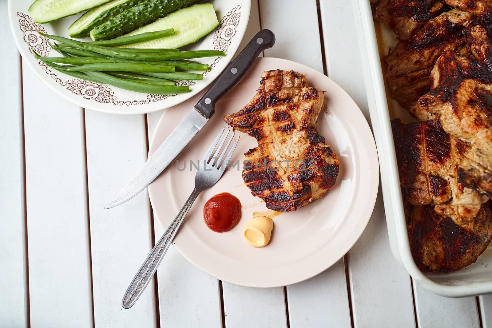 Ready pork steak in a white plate with green onions on a white plate. With copy space. High quality photo