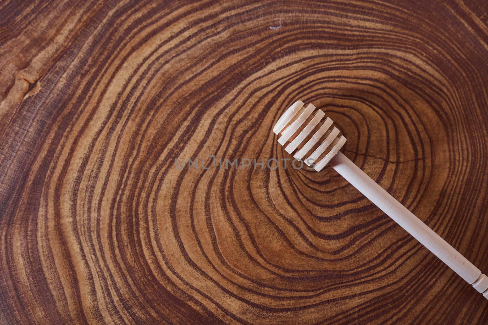 wooden honey dipper lies on a slice of a tree. wooden table. With copy space. High quality photo