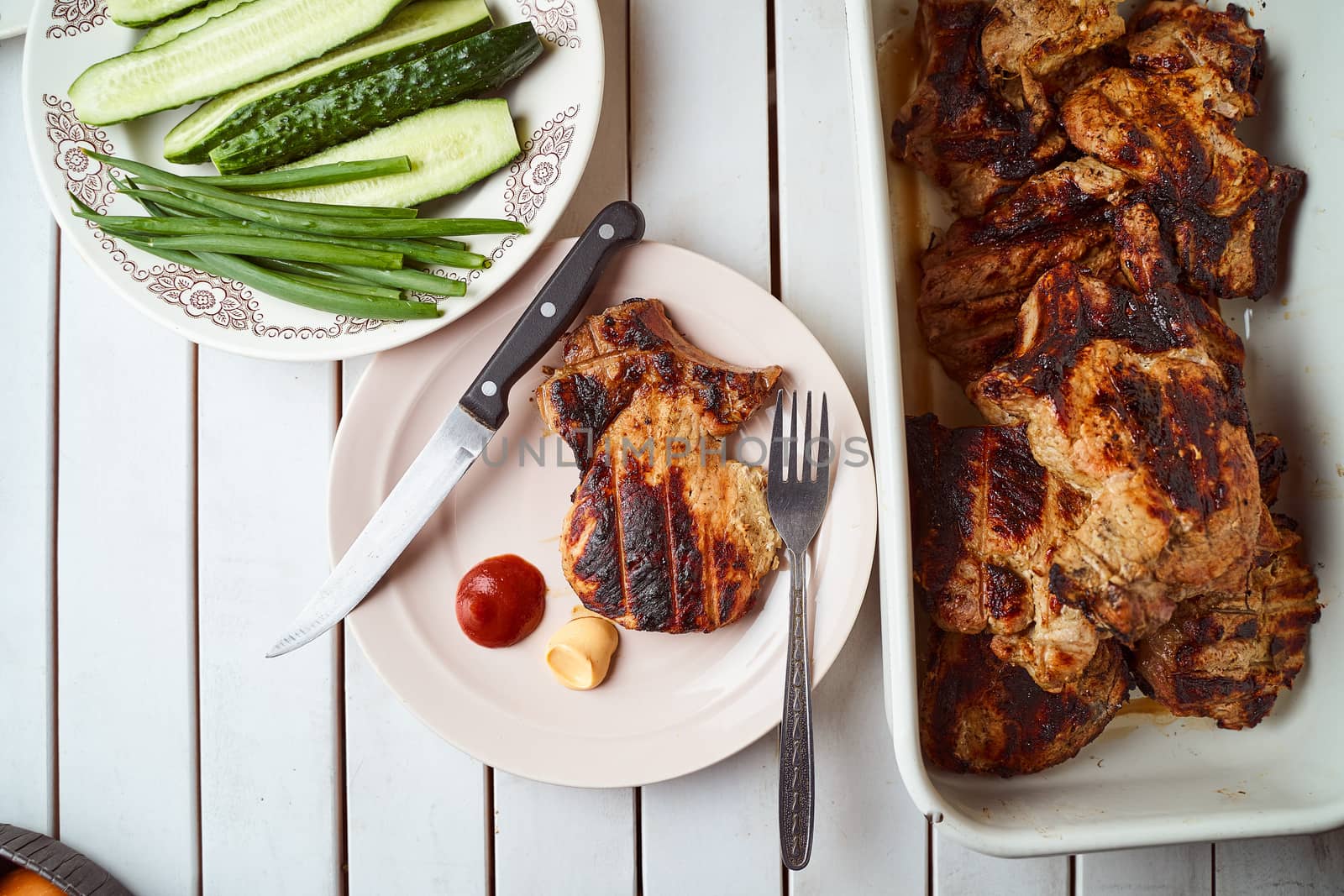 Ready pork steak in a white plate with green onions on a white plate. With copy space. High quality photo