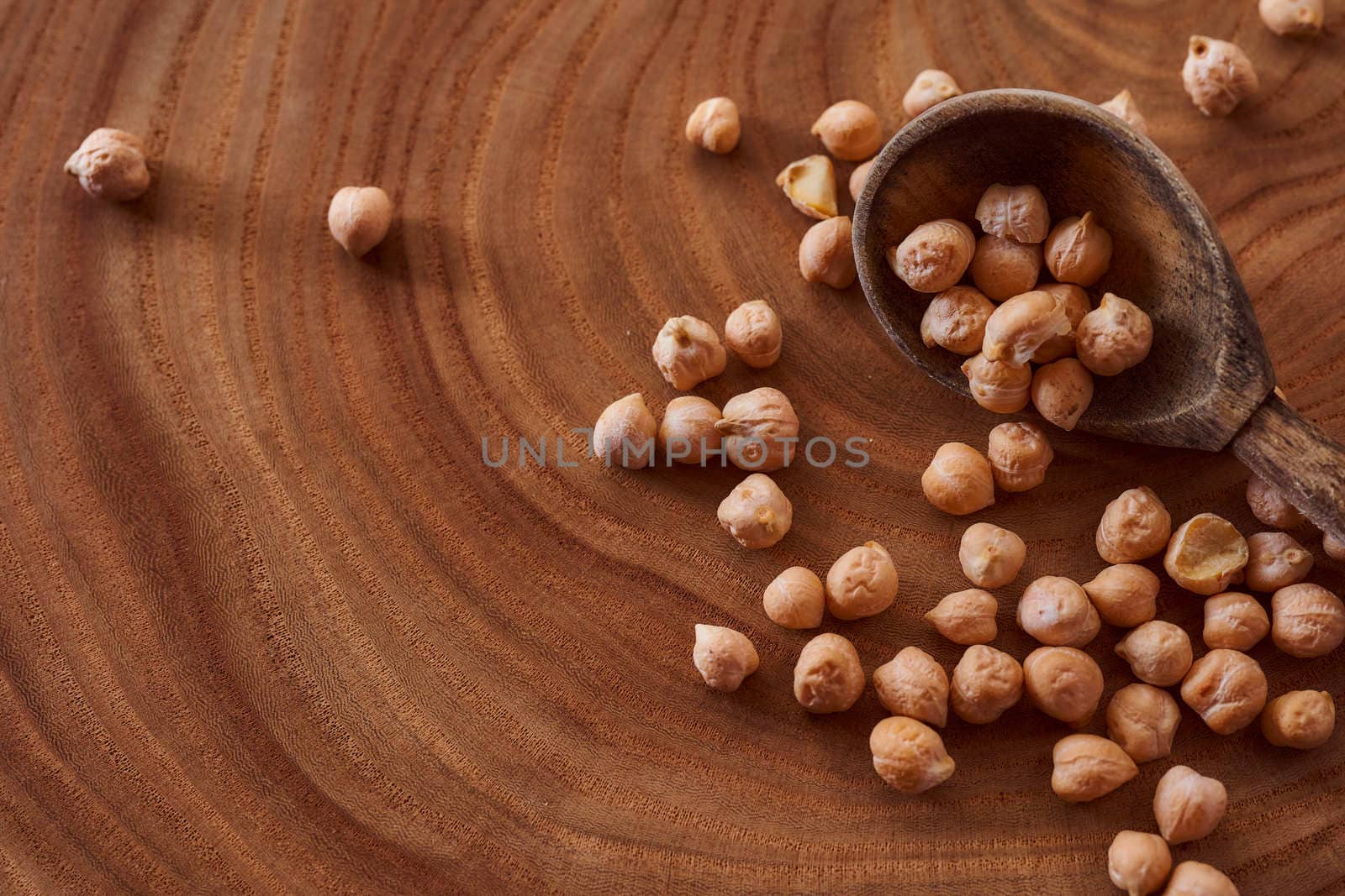 Superfood chickpeas lie in wooden background with spoon. Close-up. Top view. High quality photo