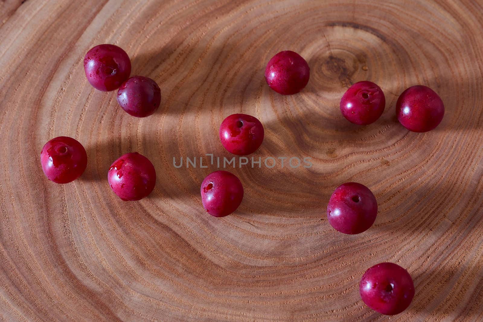 Ripe cherry berry on a wooden slice of wood by Xelar