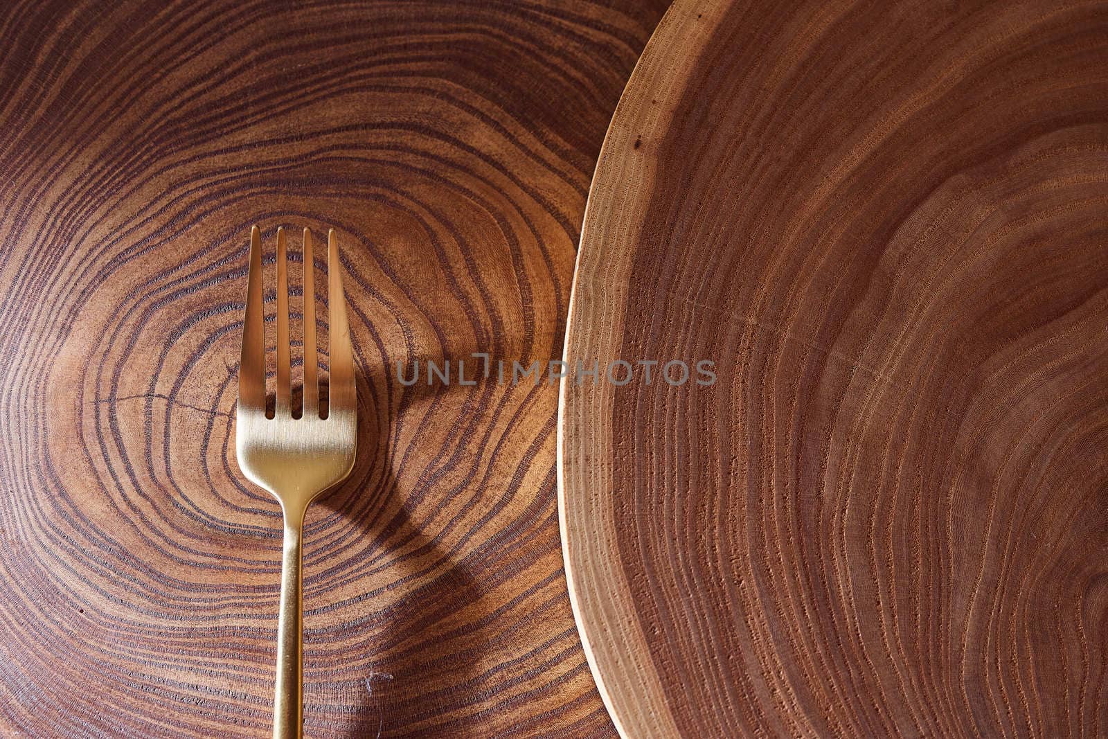 The golden fork lies on a slice of a tree. wooden table. High quality photo