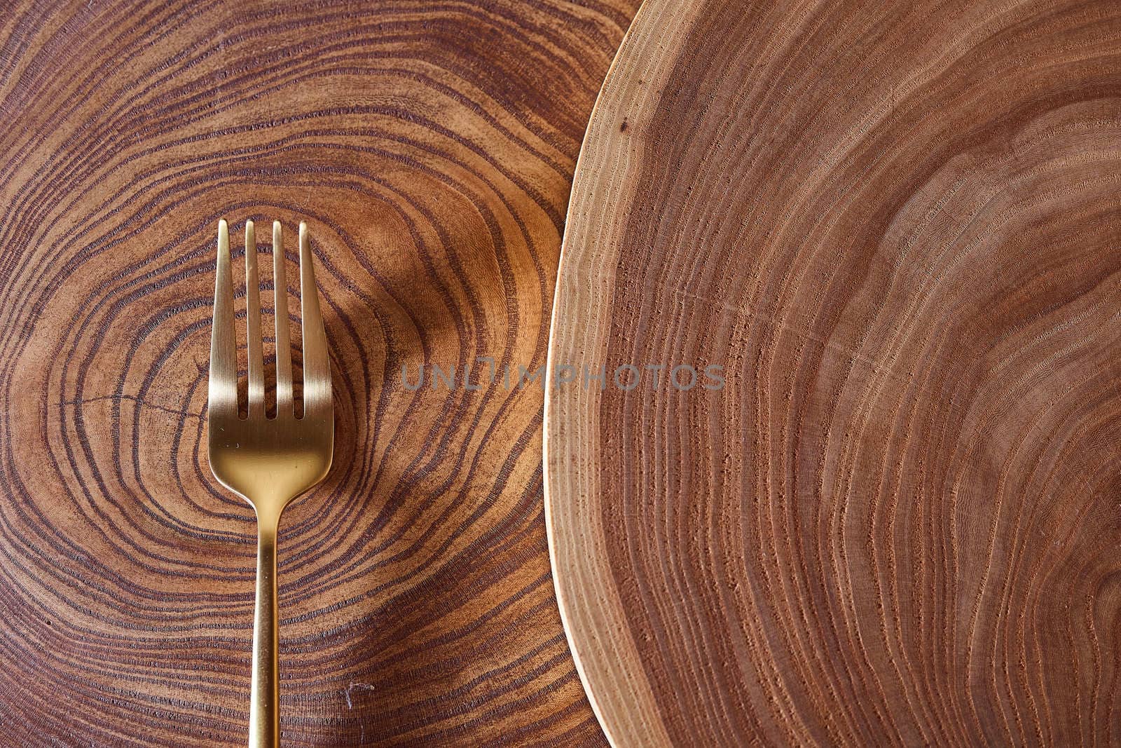 The golden fork lies on a slice of a tree. wooden table. High quality photo