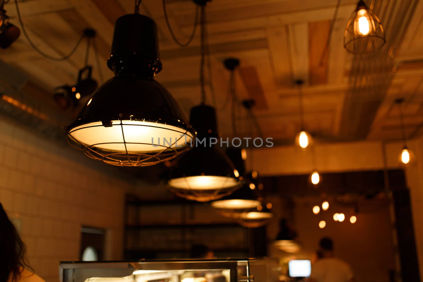 Stylish lighting lamps over a bar counter in a loft hookah bar.