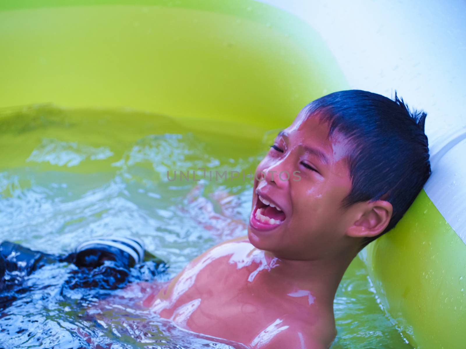 A boy playing in the pool and Smile happily.