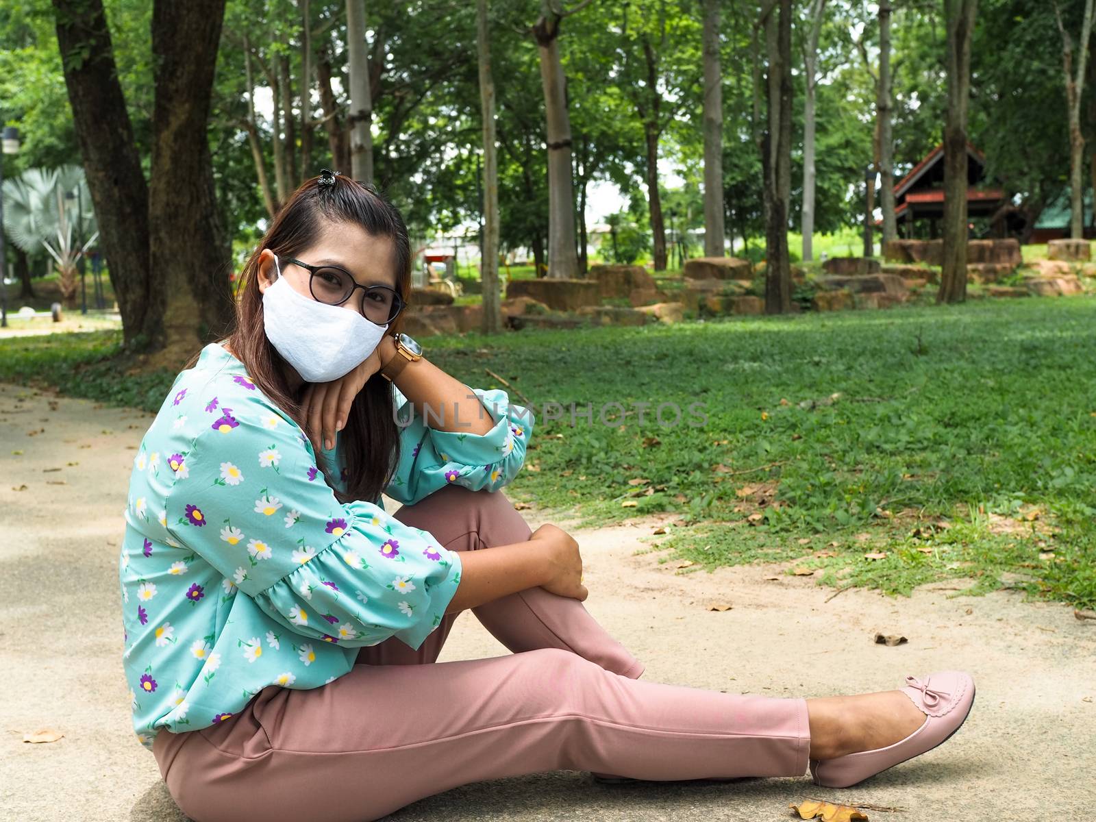 Portrait of an Asian woman Wear a face mask And sat on the floor by Unimages2527