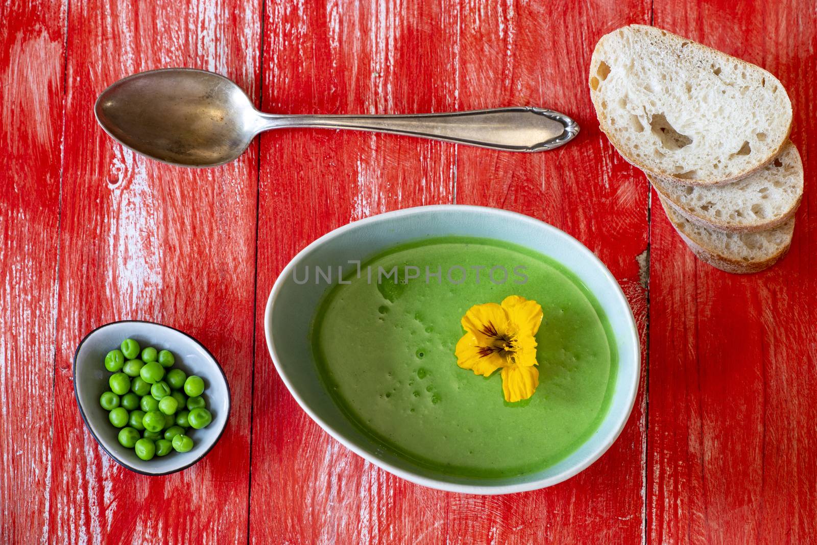 creamy pea soup on red wood