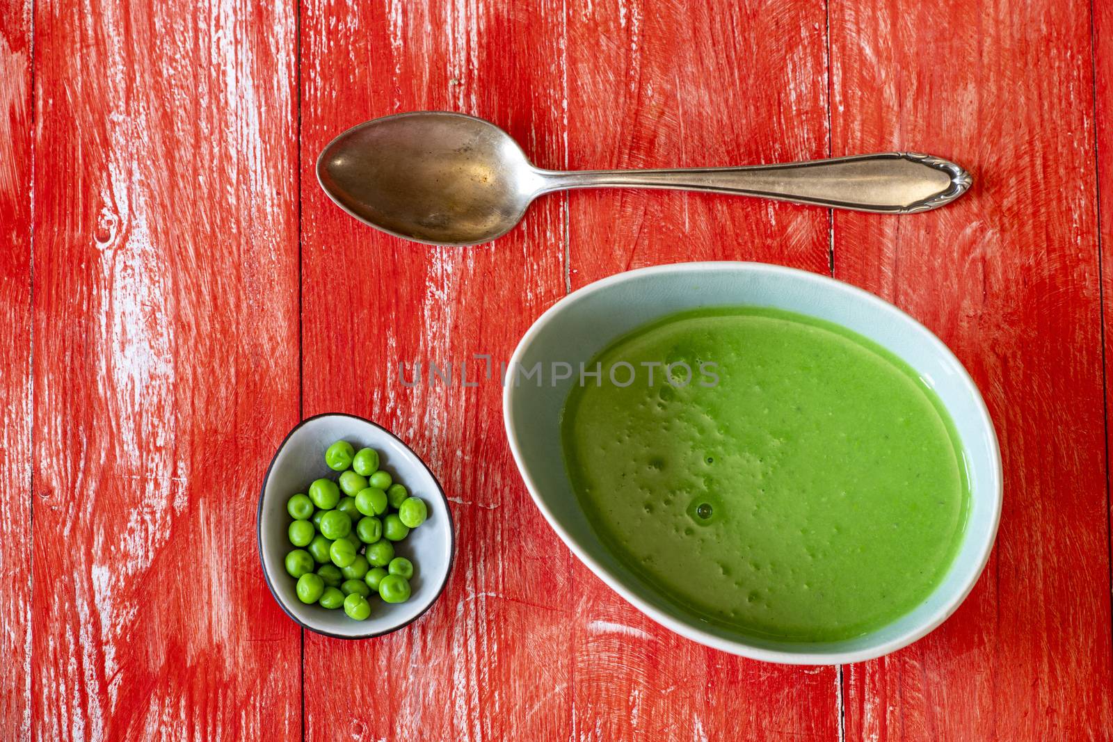 creamy pea soup on red wood