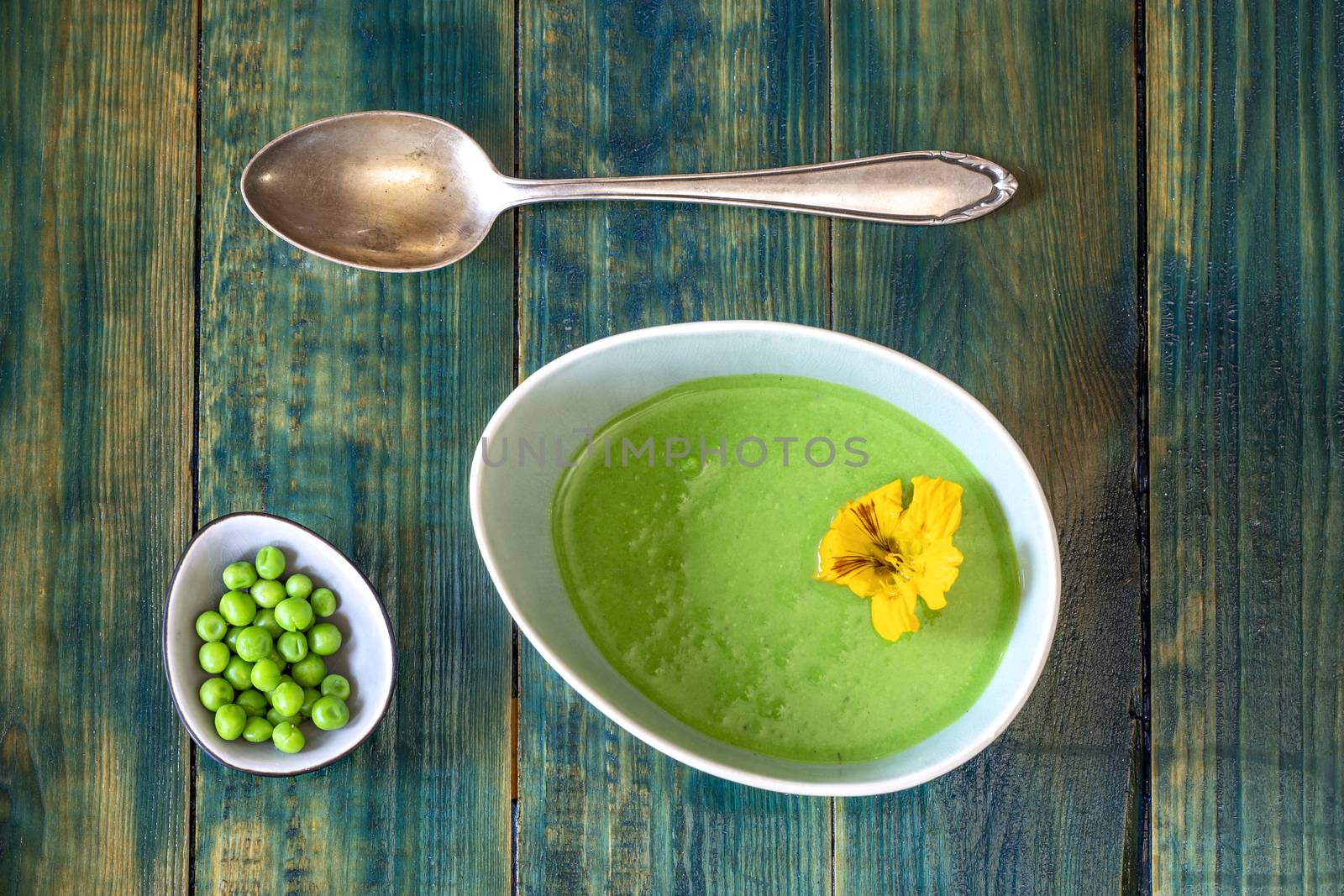 creamy pea soup on green wood