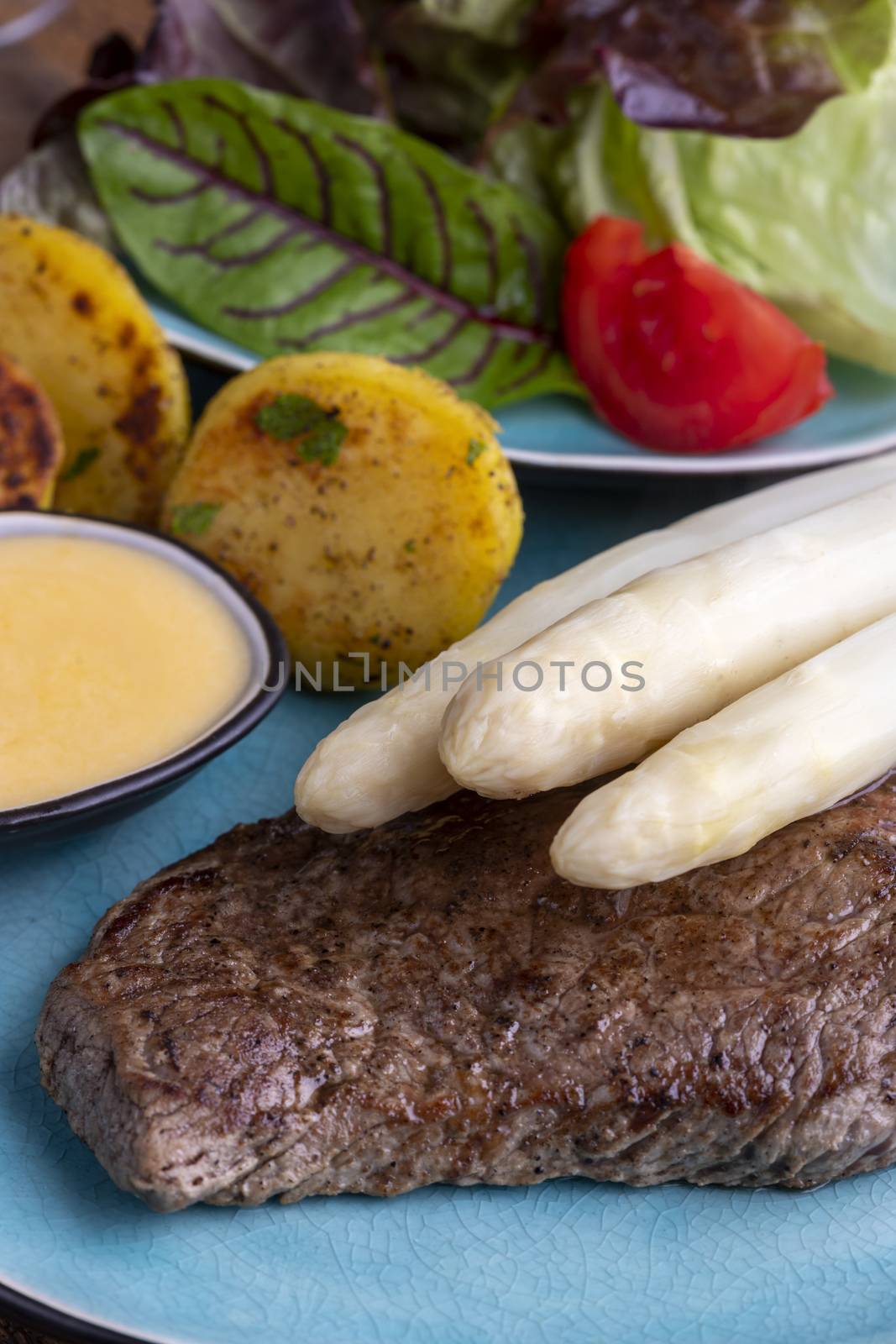 white asparagus on a grilled steak