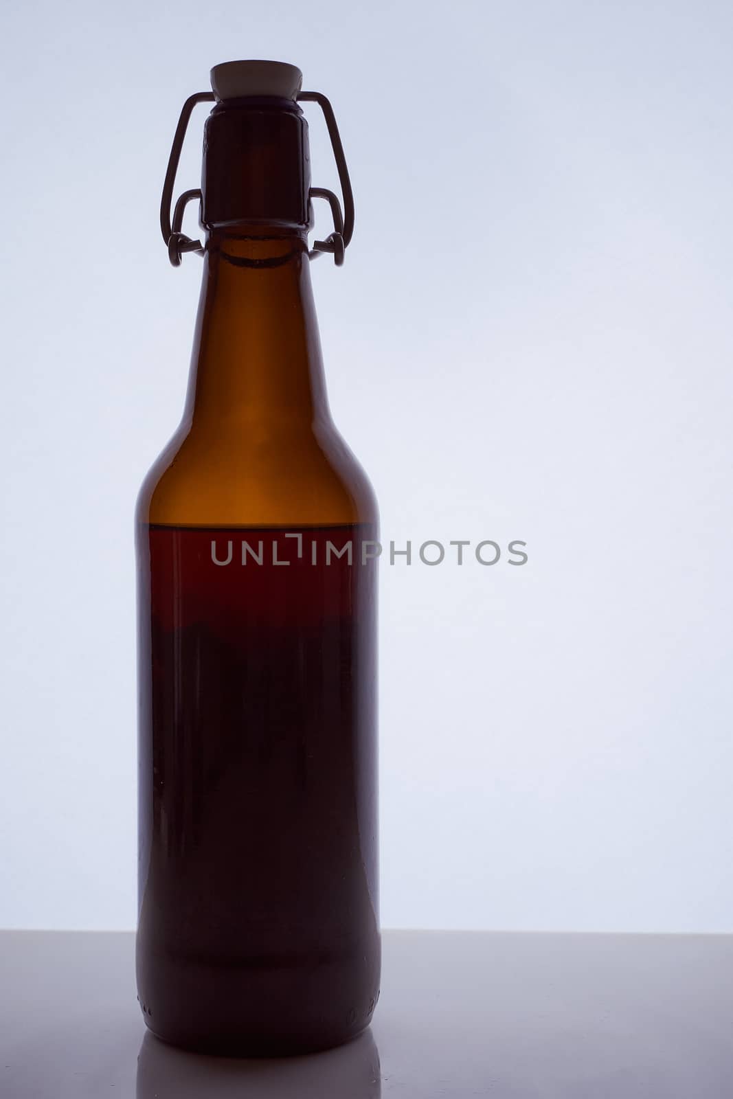 colored silhouette of a beer bottle with a cork on a black white background. Hight quality photo