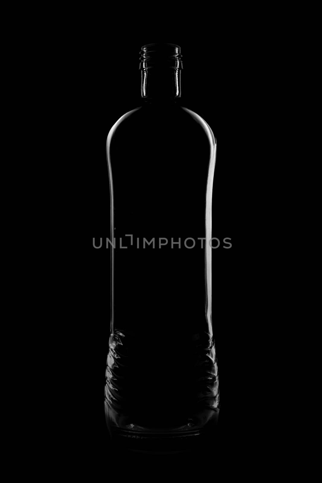 Silhouette of a bottle with a beautiful shape on a black background. High quality photo