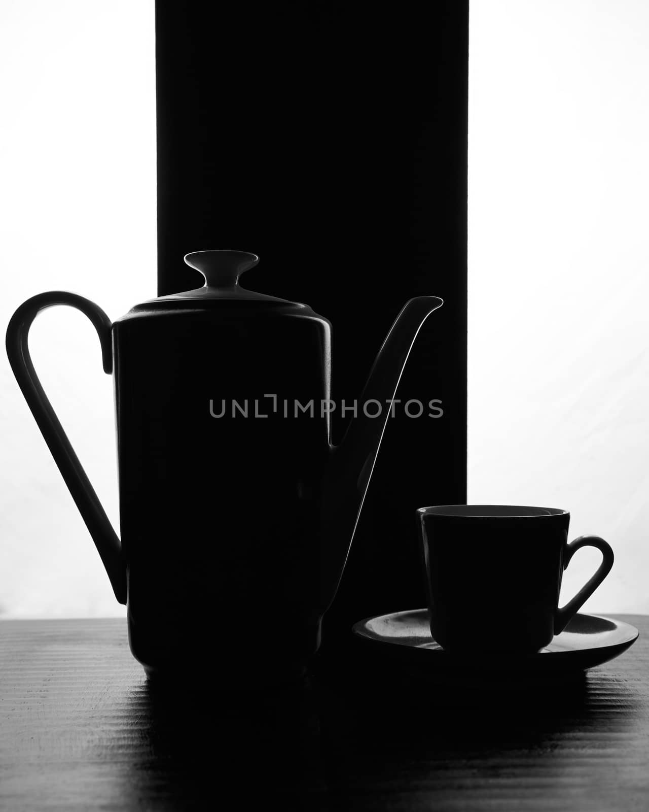 concept kettle and cups with saucer on a black white background. High quality photo