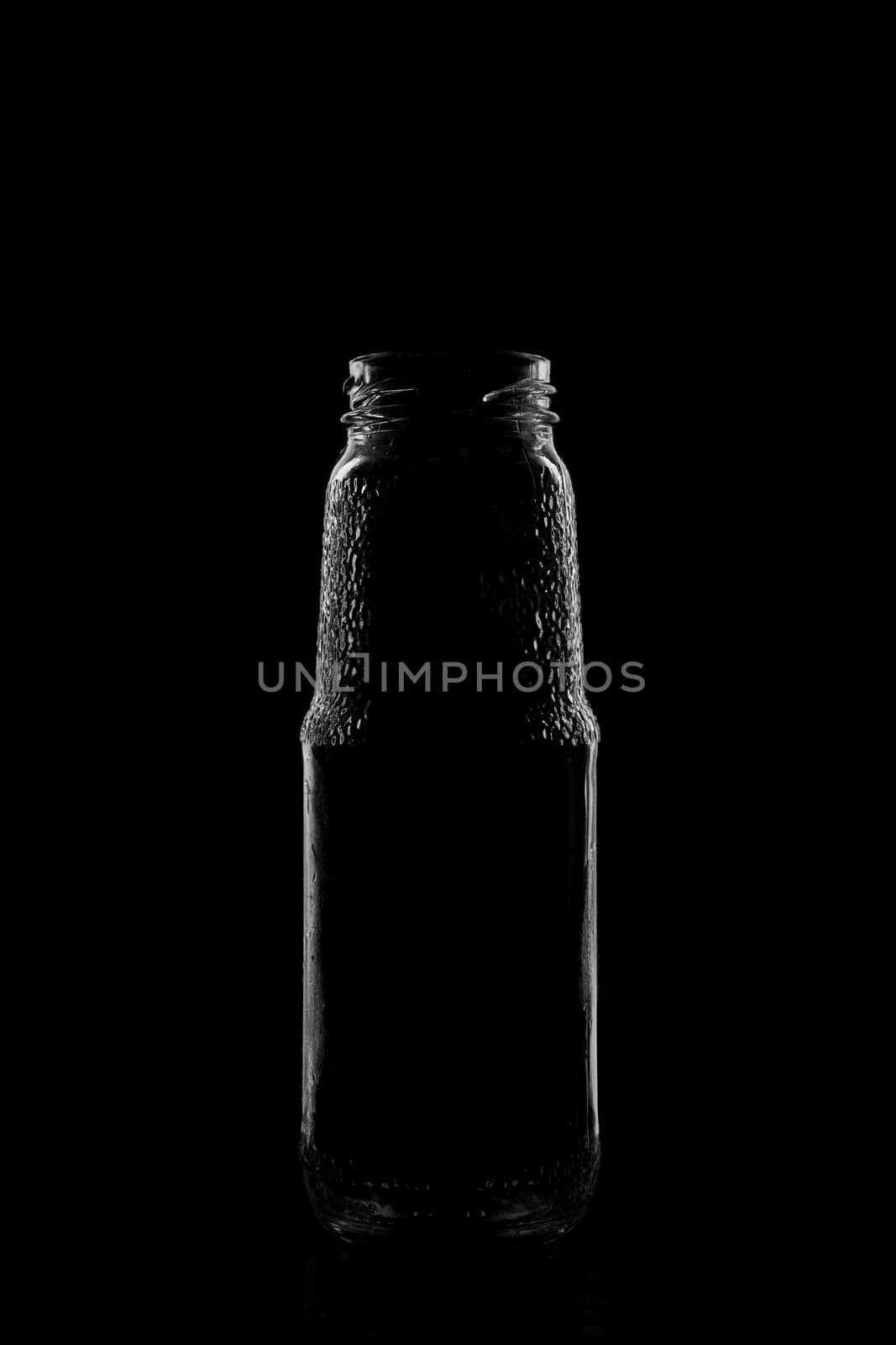 Silhouette of a bottle with a beautiful shape on a black background. High quality photo