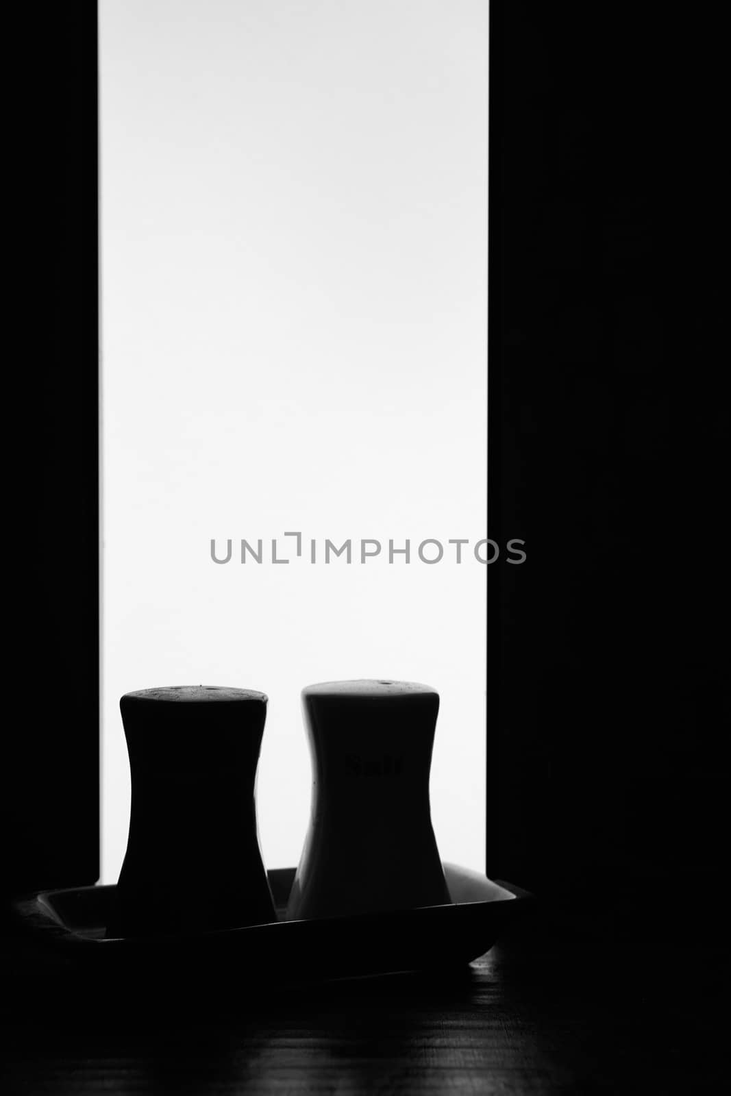 black white silhouettes of peppercorns and salt shakes on a white background. Hight quality photo