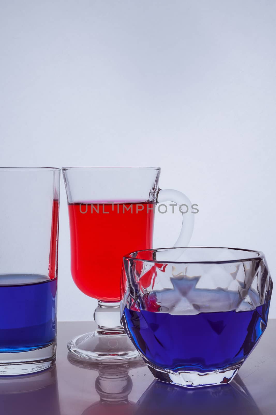 composition of different glass glasses on a white background with multicolored liquids. Hight quality photo