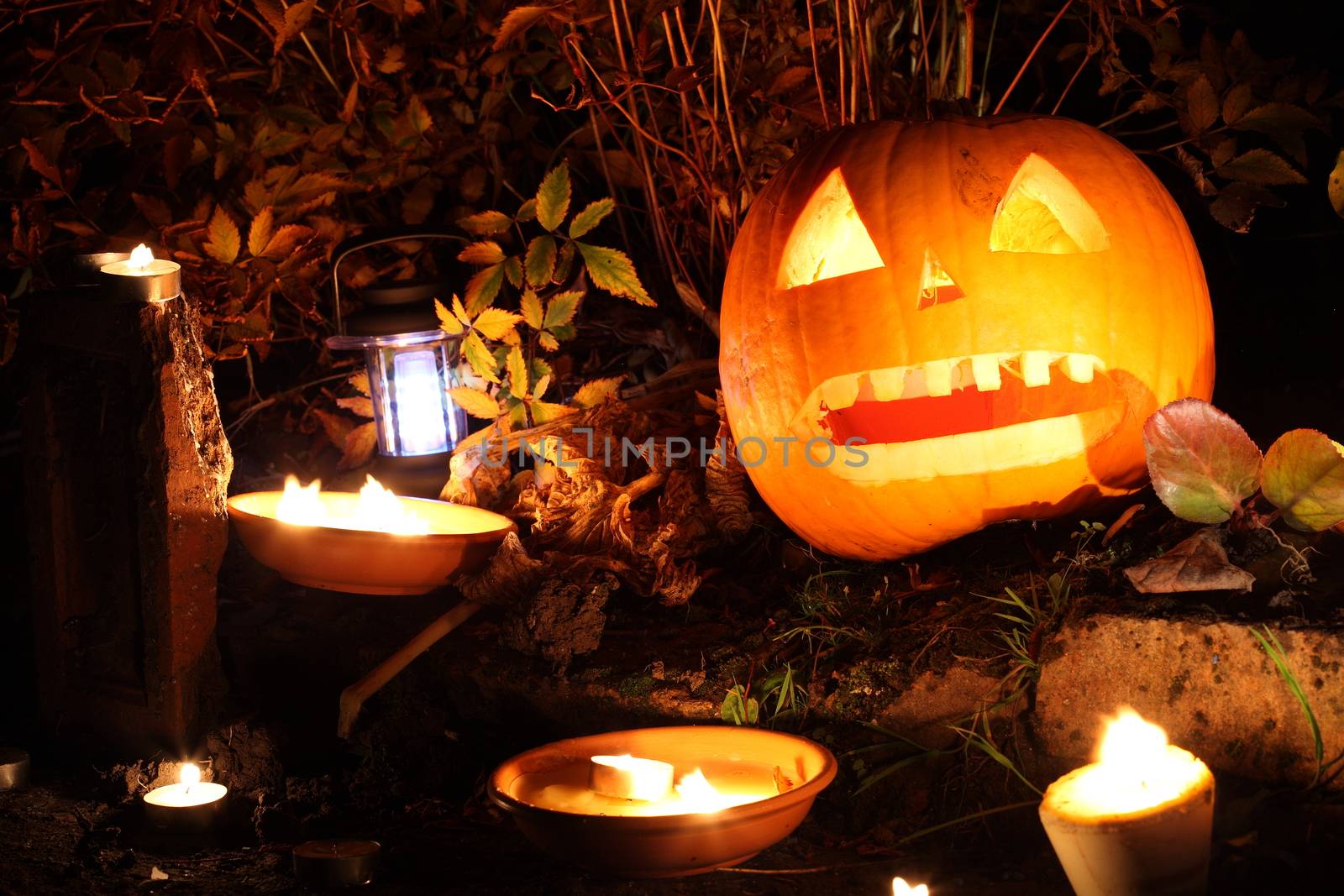 Illuminated spooky Halloween Jack O' Lantern pumpkin lantern at night in October stock photo