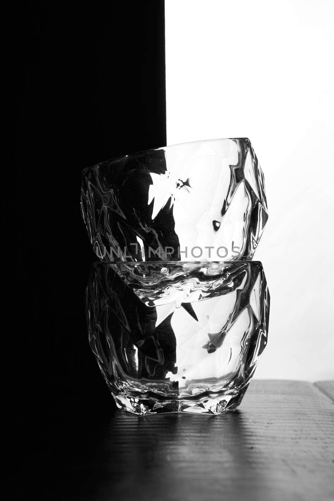 glasses of whiskey lie on top of each other. There's a bottle of whiskey next to me. Black white background. Silhouettes. High quality photo