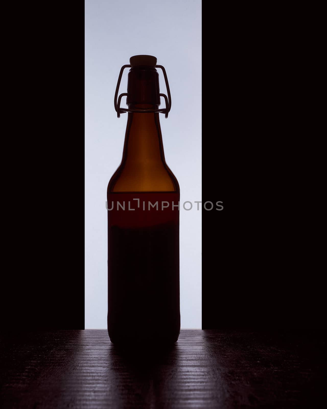 colored silhouette of a beer bottle with a cork on a black white background. Hight quality photo