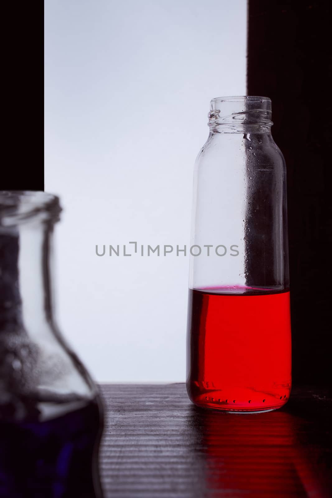 bottled on a light background with blue liquid.silhouette photo. Hight quality photo