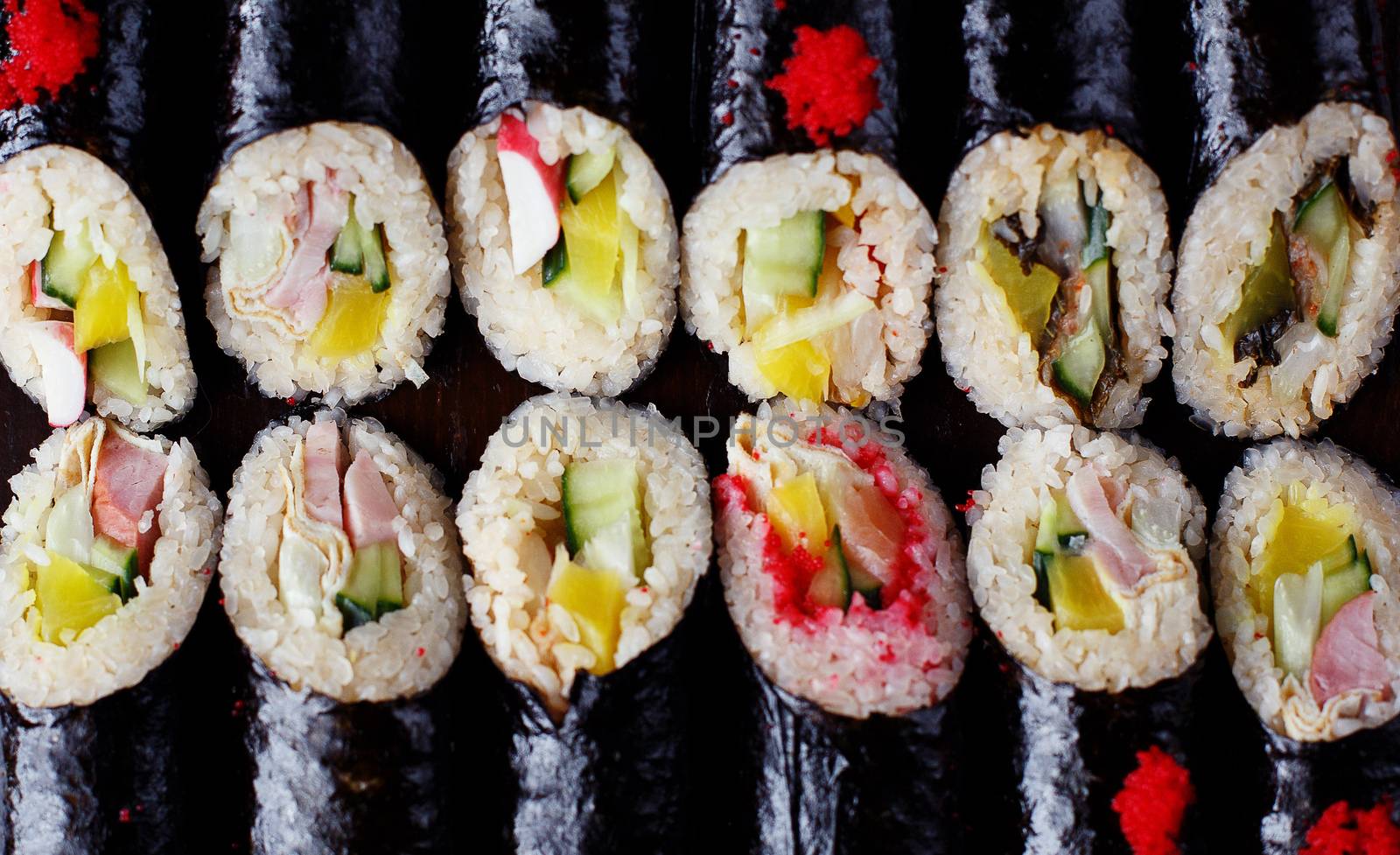 set of Korean rolls in a black shell on a white plate close up