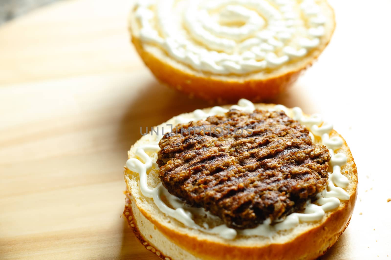 beef patty lies on a bun for a burger closeup photo