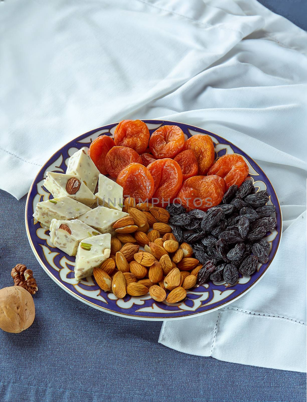 set of oriental sweets dried apricot sorbet raisins on a plate of blue and white background Beautiful concept background