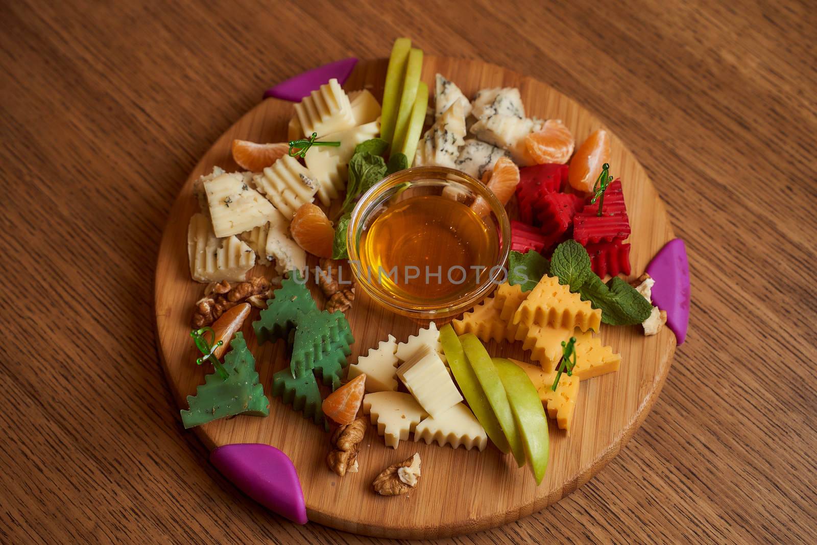chalkwith with different varieties of cheeses with honey on a wooden table closeup photo