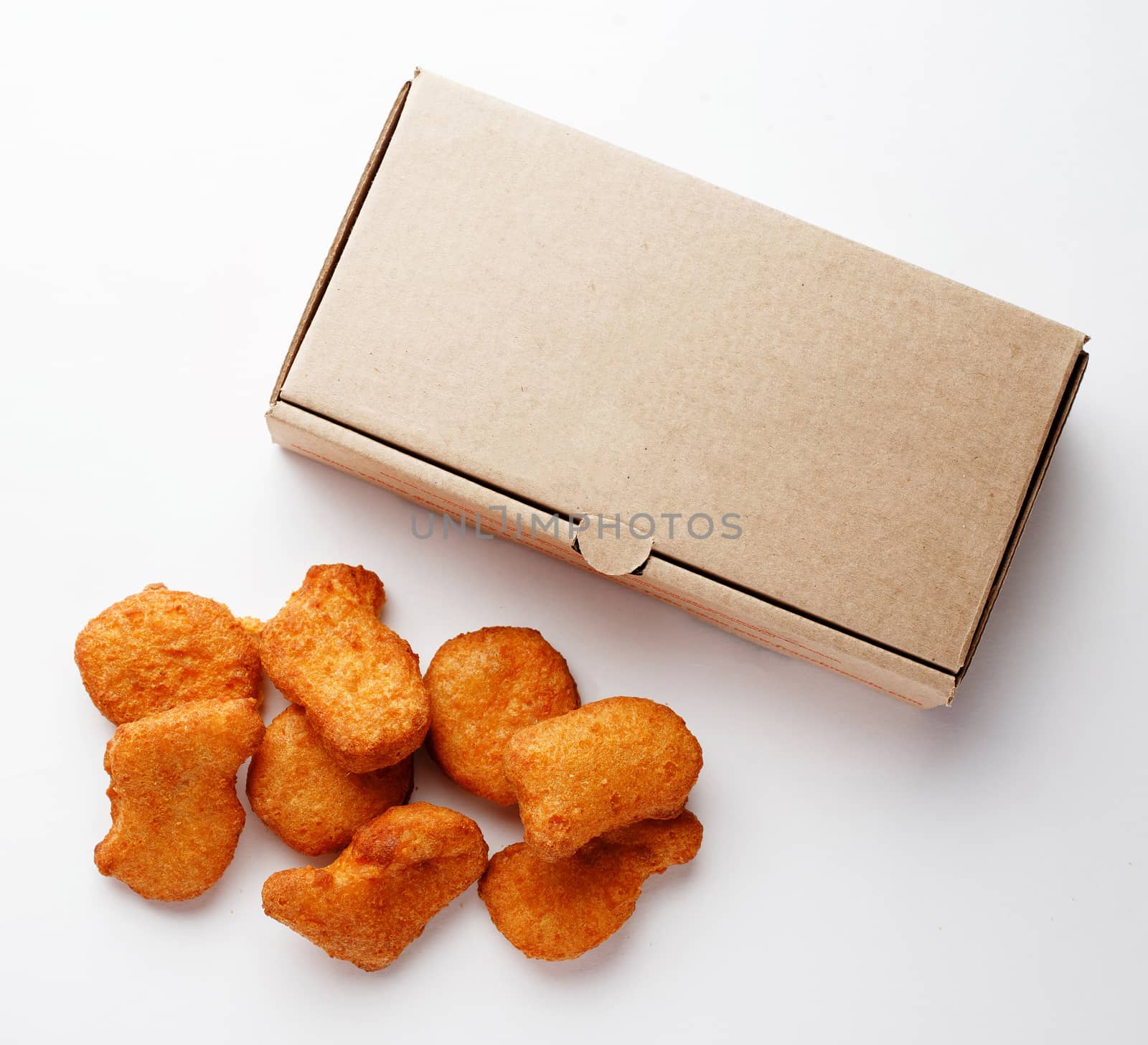 Large nuggets and cardboard box for them on a white closeup photo