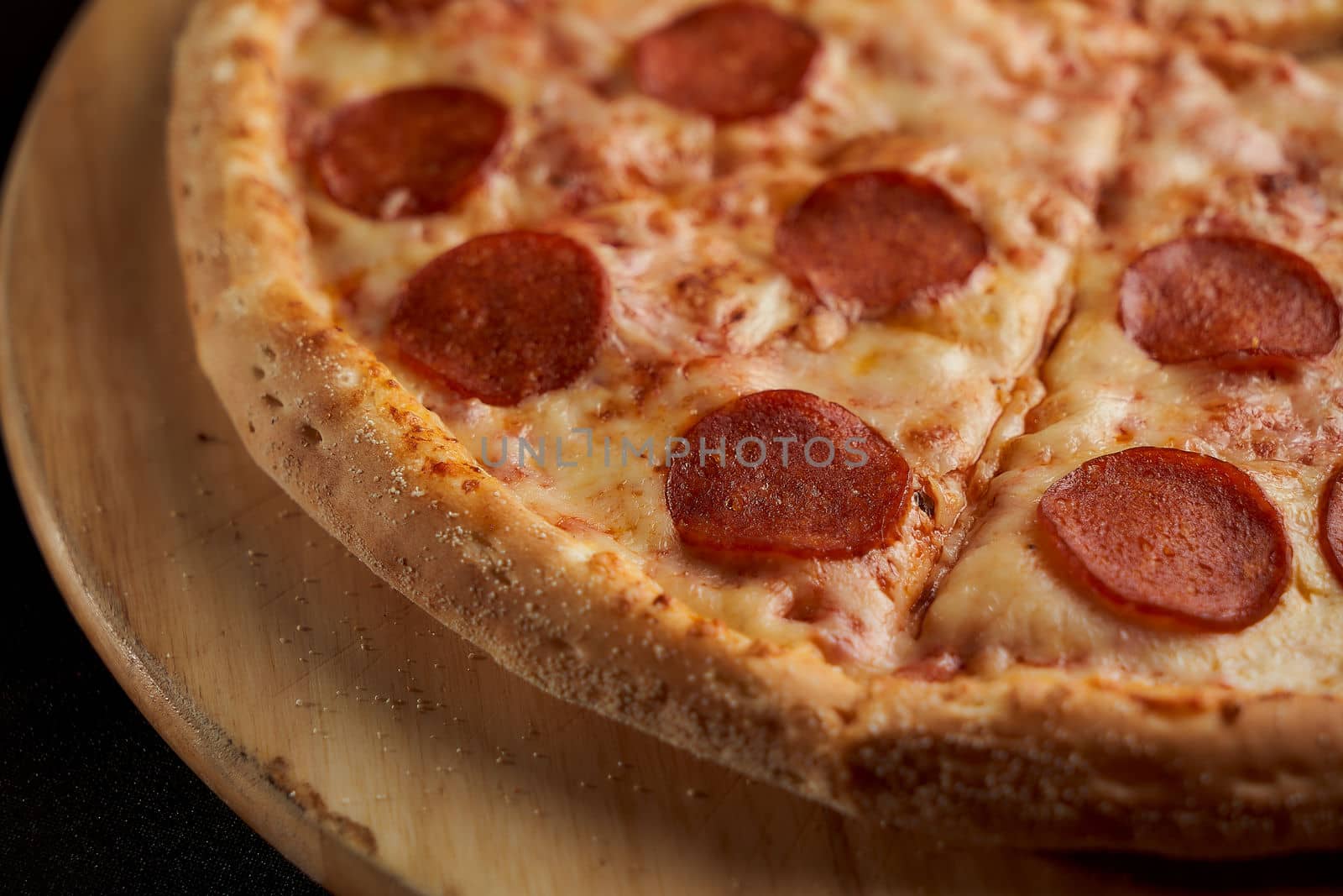 Pizza salami close-up lies on a wooden traycloseup photo