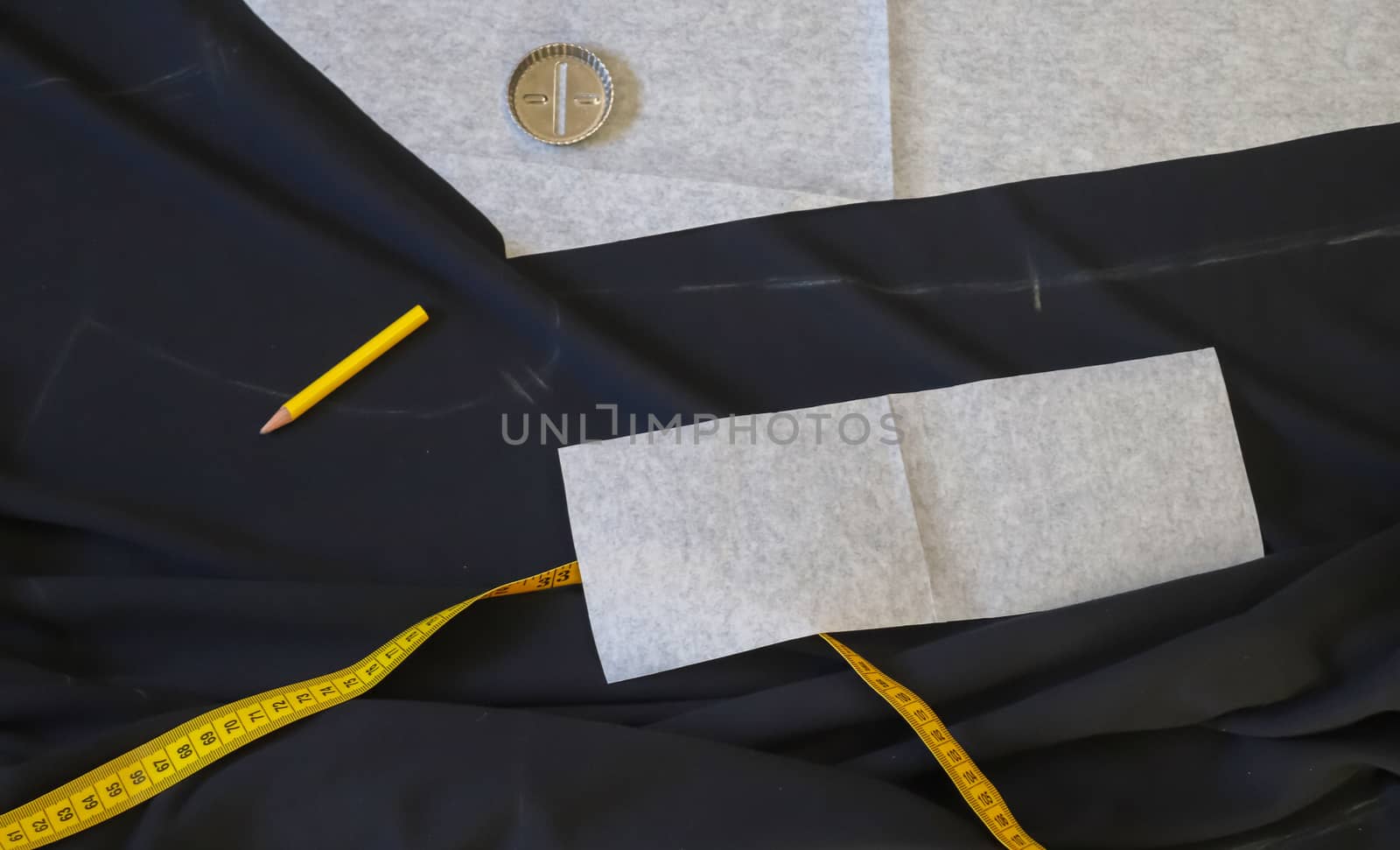 Different sewing accessoires on a black fabric background. Sewing concept.