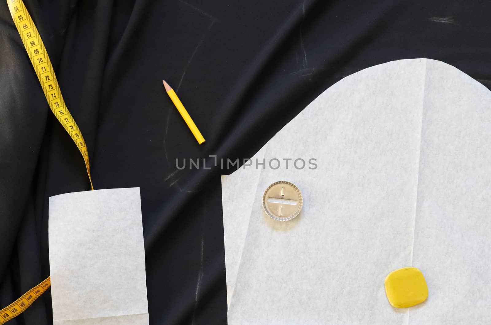 Different sewing accessoires on a black fabric background. Sewing concept.