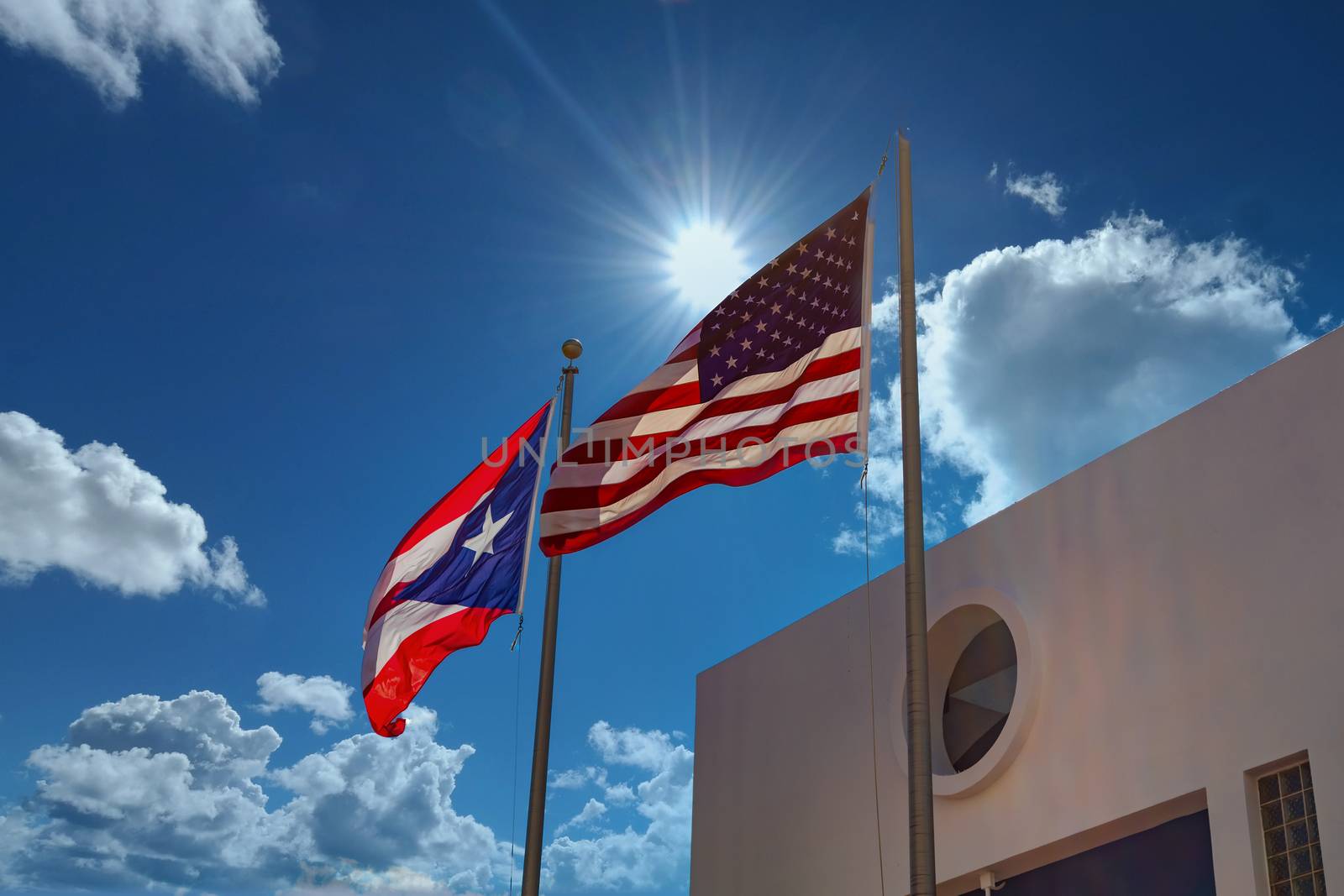 The American and Puerto Rican Flags flying under a sunny sky