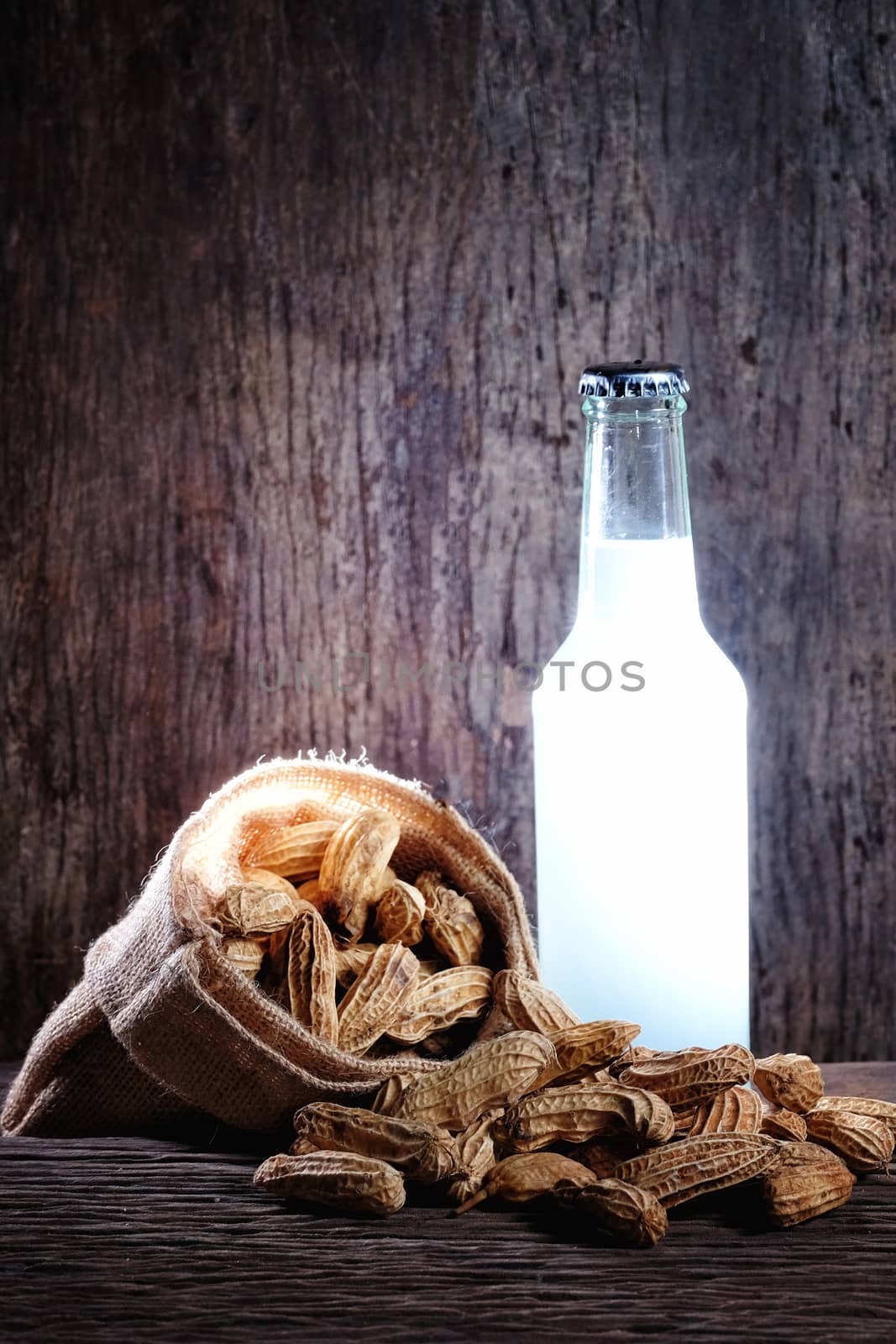 Peanuts and beer in on wood background