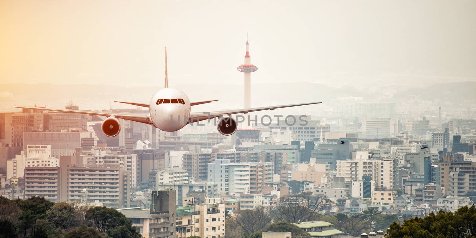 Airplane frying over the kyoto tower background by Surasak