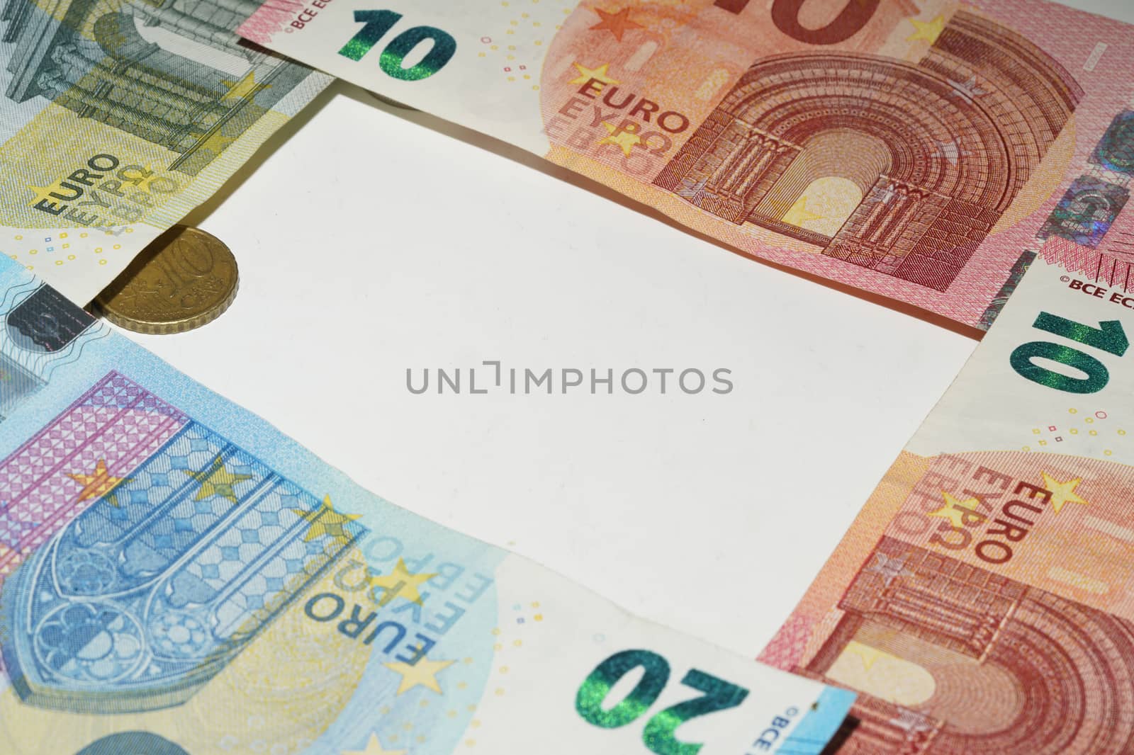 Close-up of euro notes and coins on a white background with copy space.