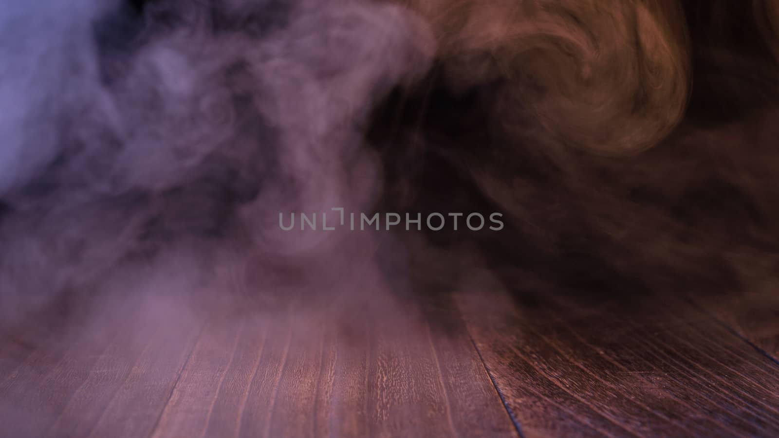 Conceptual image of multi-colored smoke isolated on dark black b by ROMIXIMAGE