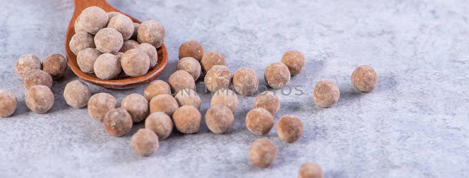 Dry raw brown tapioca pearls isolated on gray cement concrete background, close up, ingredient of making bubble boba tapioca milk tea.