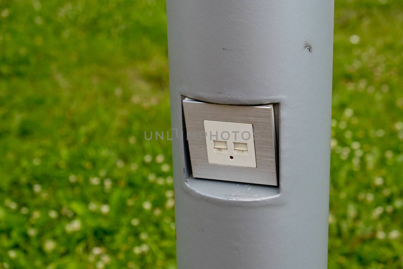 USB socket for charging mobile phones on a pole in the park.