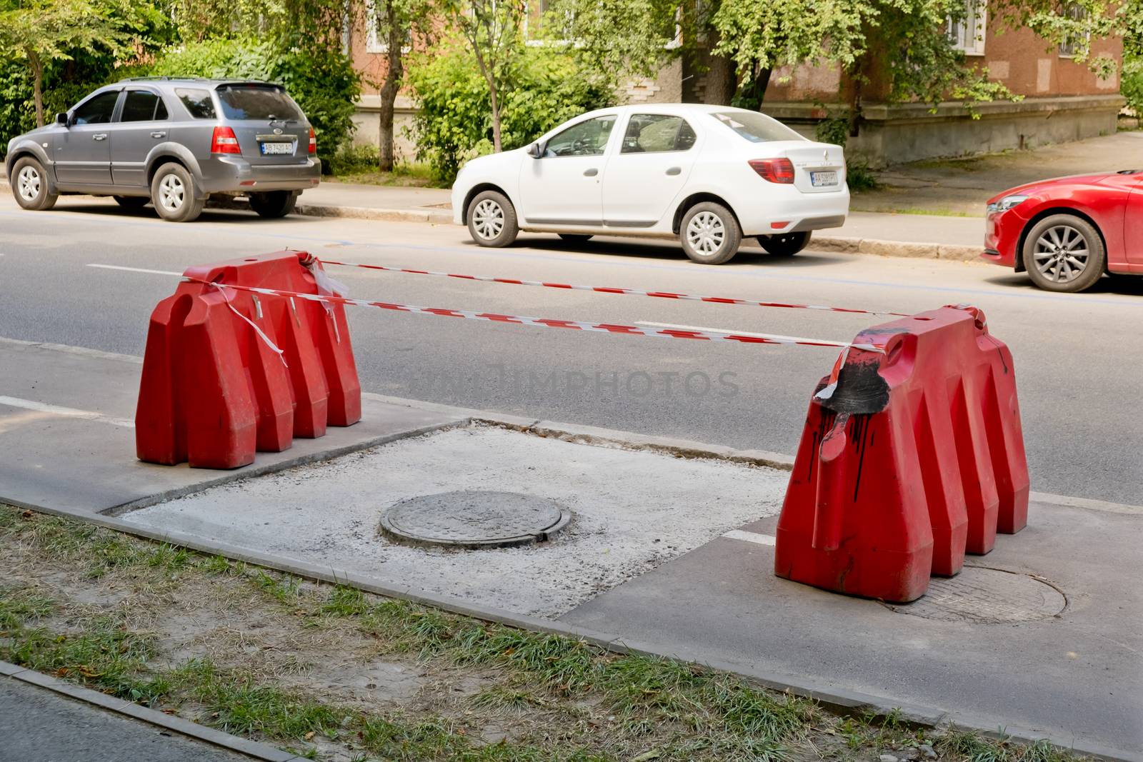 Vinnytsia, Ukraine - July 2020: Repair of the bike path. Red block surround an asphalt repair job.