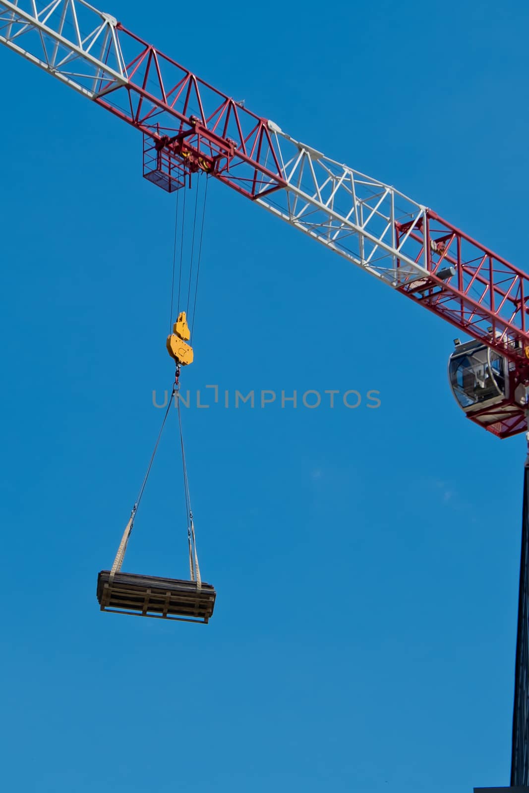 The crane lifts a heavy load on a hook.