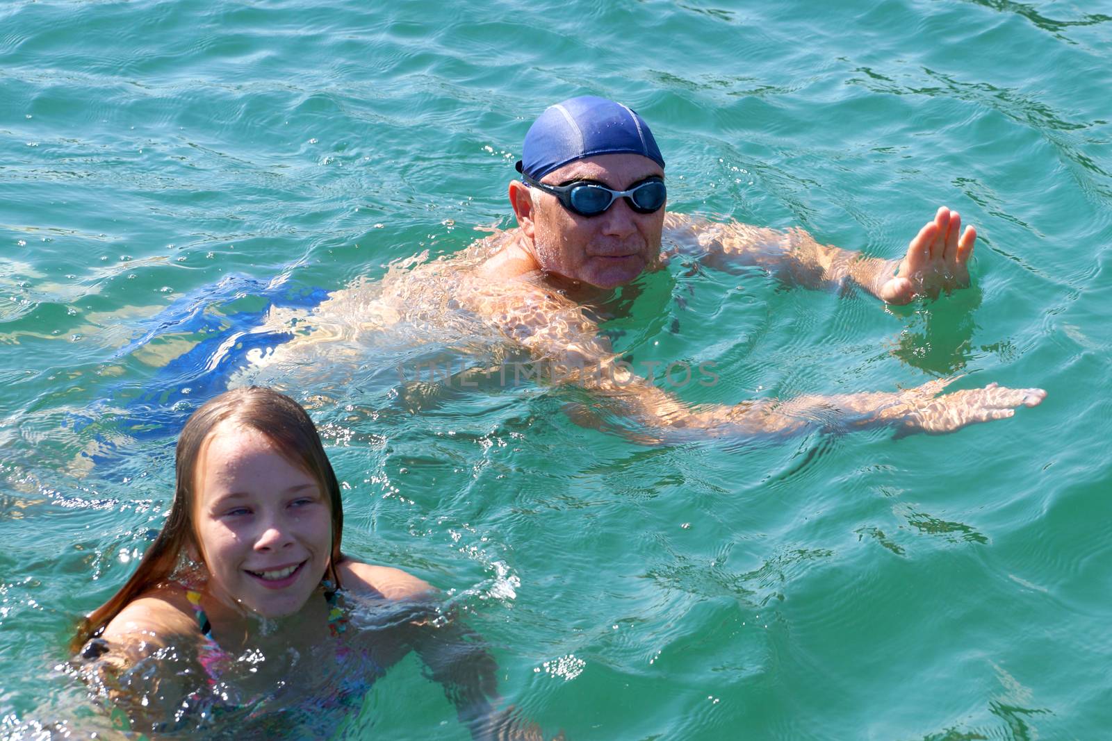 joyful man and daughter swim in the sea close-up