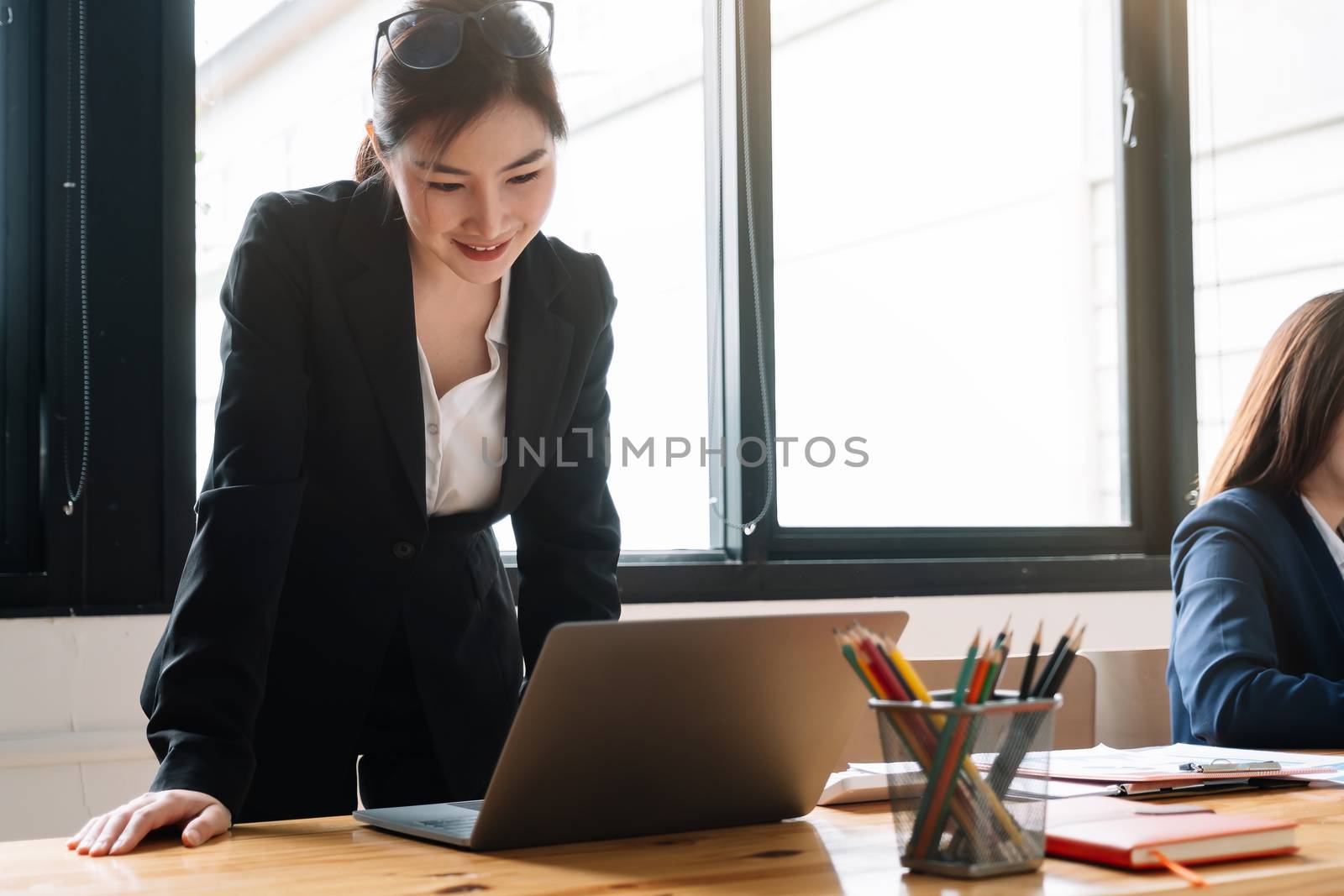 Portrait Of Attractive Asian Businesswoman Working On Laptop for marketing plan.