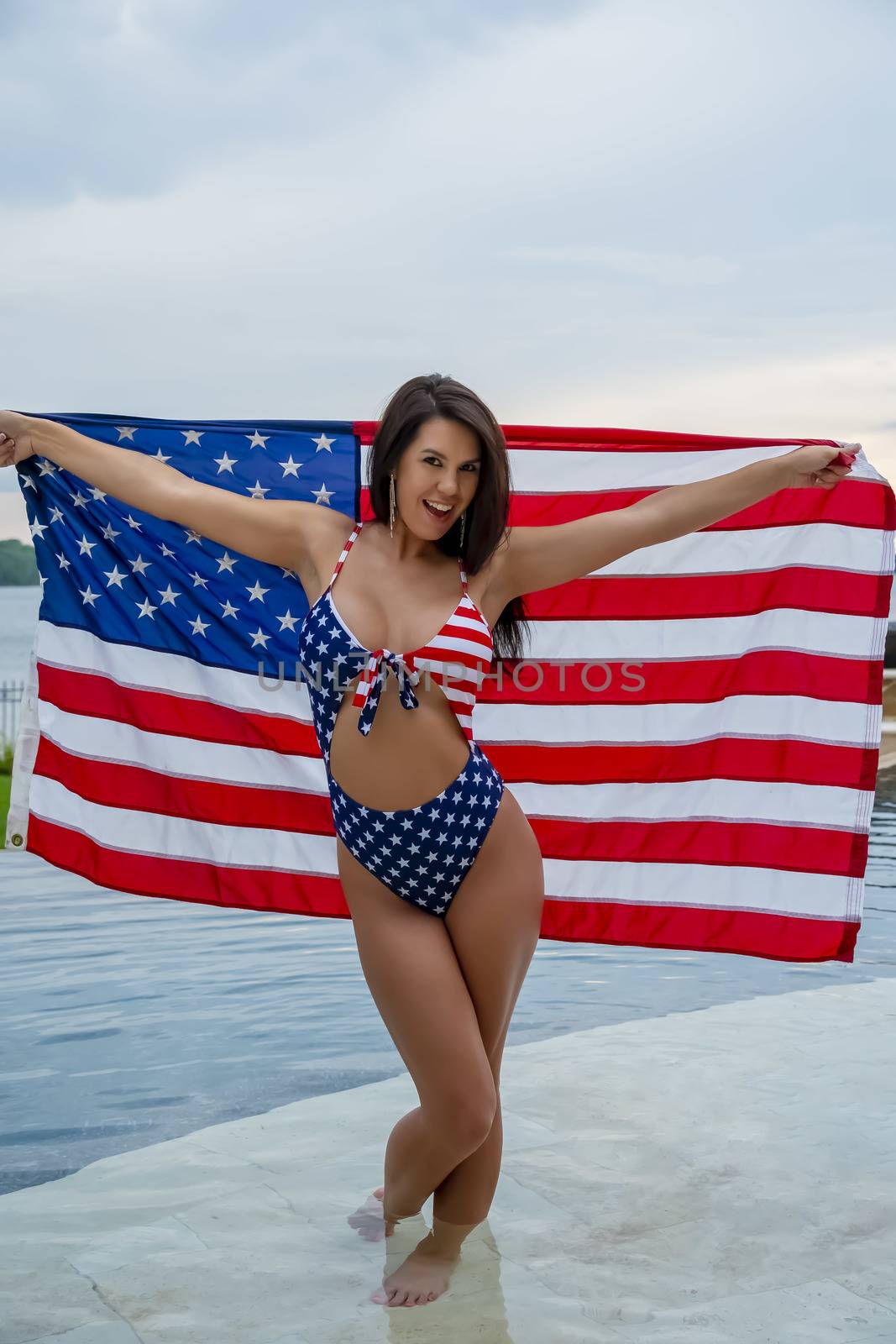 Portrait of a woman wearing a patriotic American bikini while holding an American flag