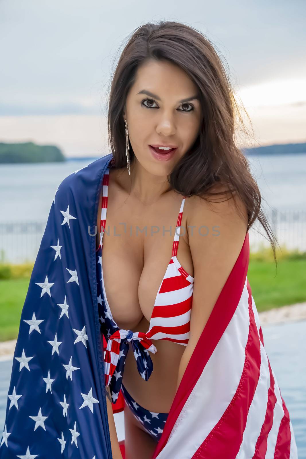 Portrait of a woman wearing a patriotic American bikini while holding an American flag