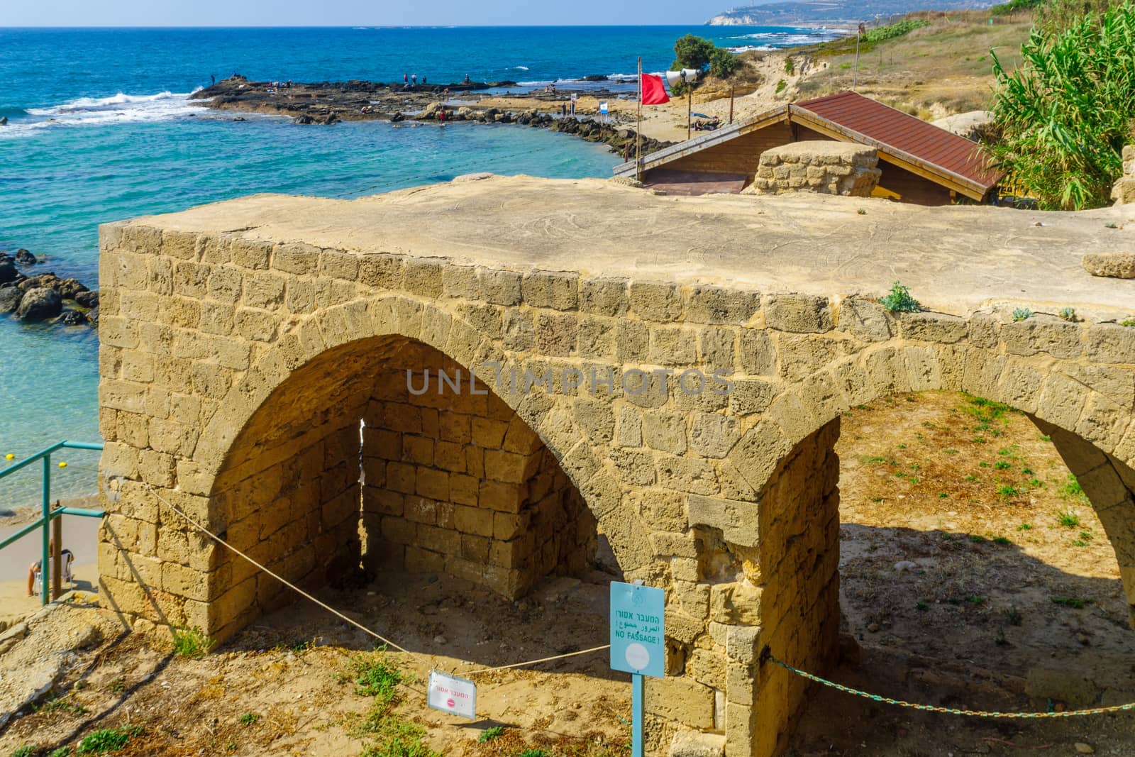 Achziv, Israel - July 22, 2020: View of an old building and the coast, with visitors, in Achziv national park, northern Israel