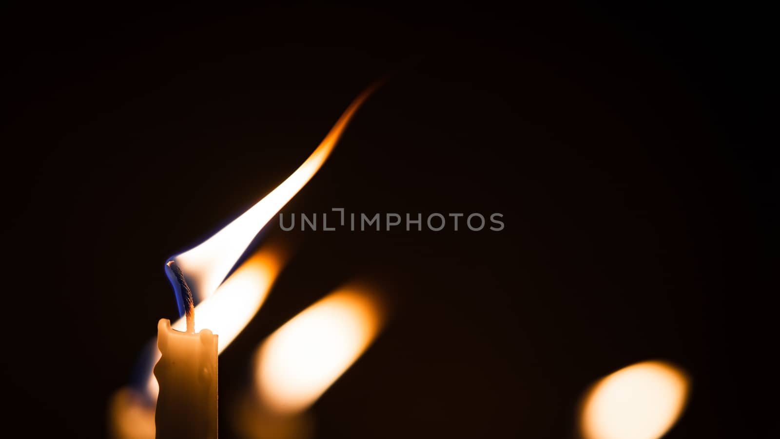 Close-up shots of yellow candles and lights on a black background with bokeh lights