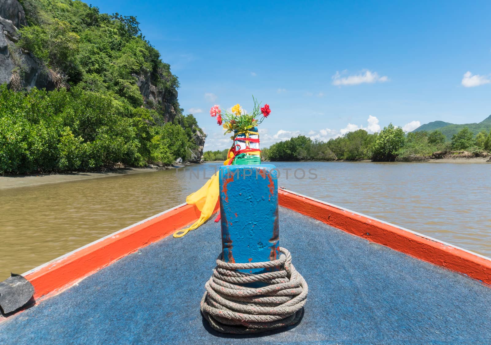 Khao Dang canal boat trip at Prachuap Khiri Khan Thailand. Boat or fishing boat and rock or stone mountain or hill with blue sky and cloud and green tree and water. Landscape or scenery summer concept for boat trip